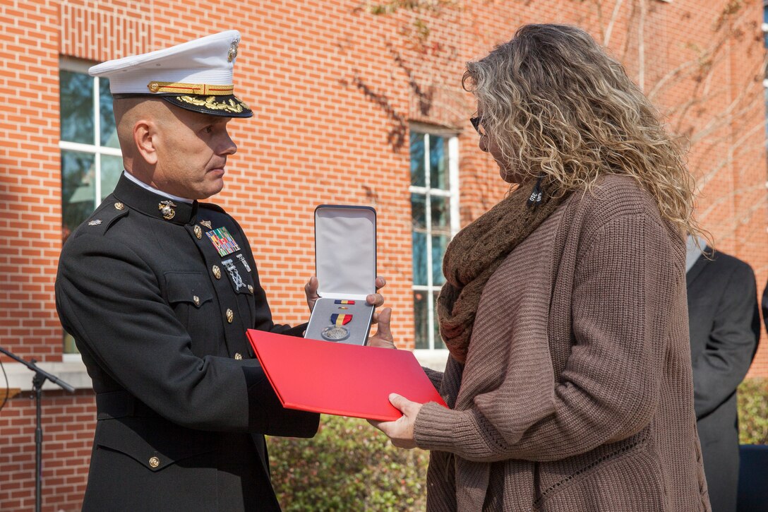 Janice Smarr, the mother of Lance Cpl. Nicholas Smarr, accepts the Navy and Marine Corps Medal on behalf of her son from Lt. Col. Charles Daniel, the executive officer for Marine Light Attack Helicopter Squadron 773, at Georgia Southwestern State University in Americus, Ga., Dec. 7, 2018. The Navy and Marine Corps medal is the highest non-combat decoration awarded for heroism by the Department of Defense. (U.S. Marine Corps photo by Cpl. Niles Lee)