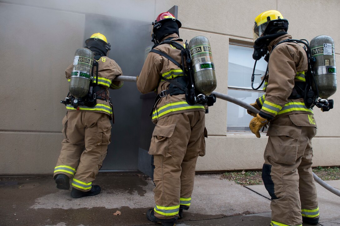 Fire protection members assigned to the 97th Civil Engineer Squadron enter a facility that is filled with imitation smoke