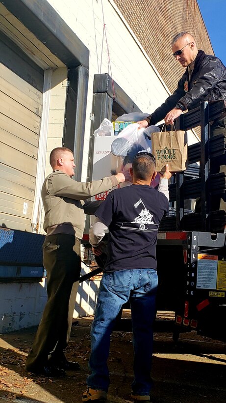 Marine Col. William C. Bentley III, commanding officer of Marine Corps Base Quantico (MCBQ) and Sgt. Maj. Michael W. Hensley, sergeant major of MCBQ, delivers the base's donations to the Toys for Tots Northern Virginia campaign's warehouse in Fredericksburg, December 6, 2018