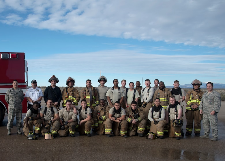 Firefighters from the 49th Civil Engineer Squadron pose for a group photo after completing a live burn exercise Dec. 3, 2018, on Holloman Air Force Base, N.M. Holloman has three fire stations with over 80 personnel. (U.S. Air Force photo by Airman 1st Class Kindra Stewart)