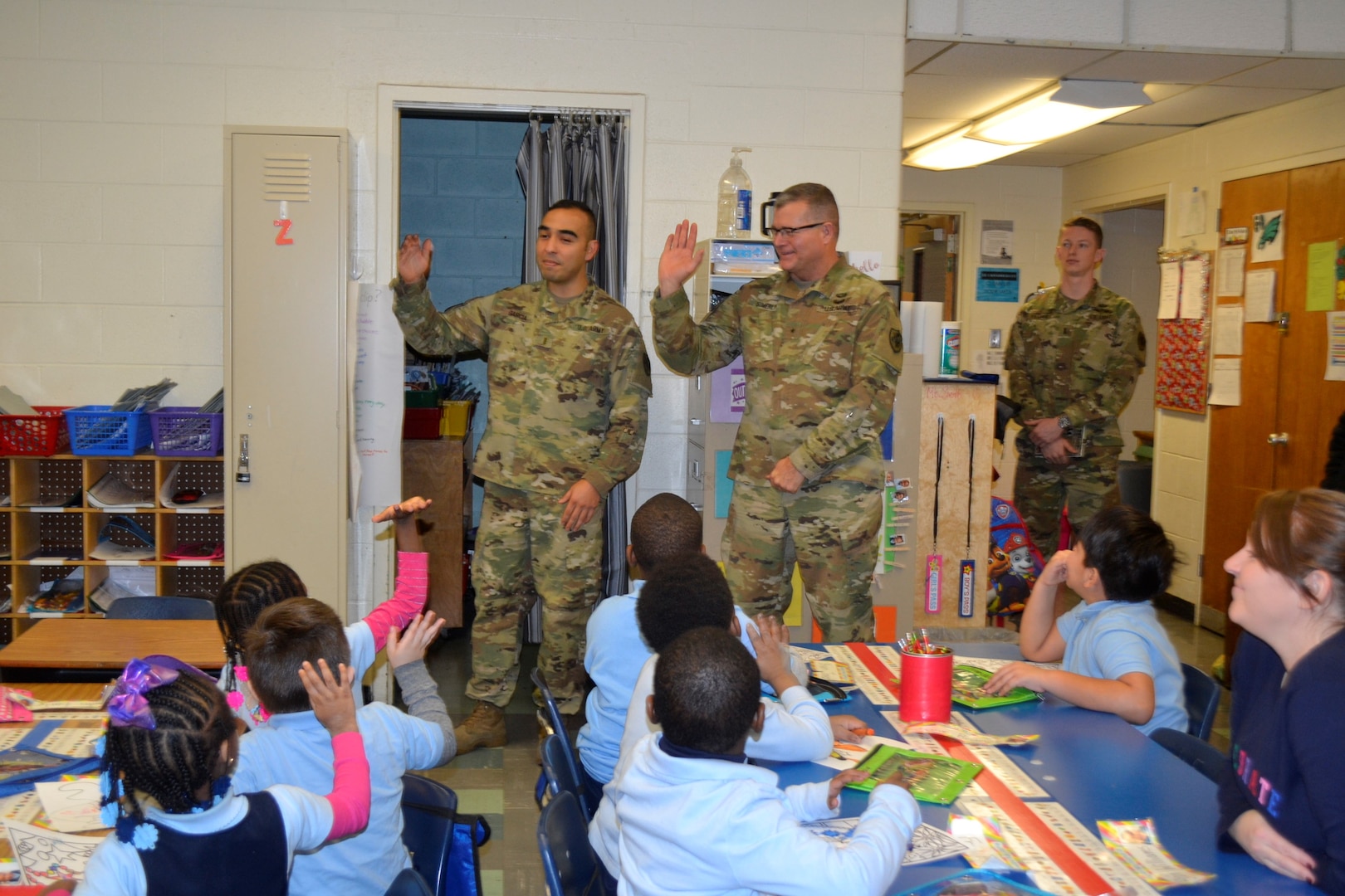 Army Chief Warrant Officer 3 Eugene Garcia, left, Brig. Gen. Mark Simerly, DLA Troop Support commander, middle, and 1st. Lt. Riley Kramer, DLA Troop Support Aide-de-Camp, right, greet students during the Children’s Holiday Party at Benjamin Franklin Elementary School Dec. 6, 2018 in Philadelphia.