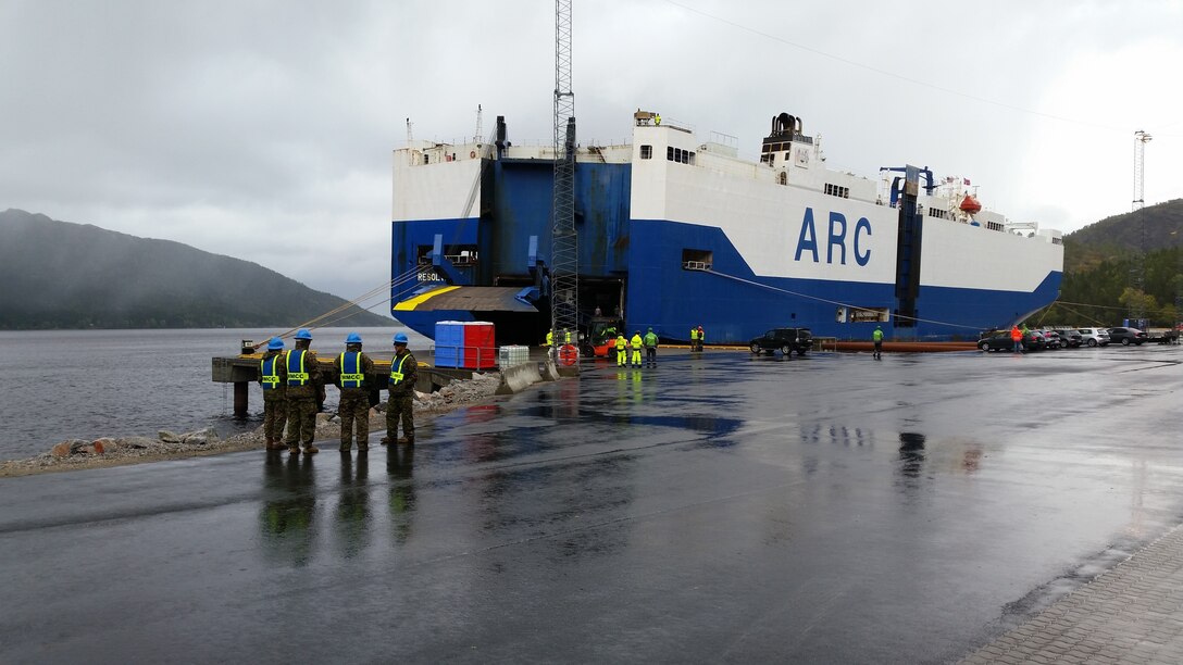 U.S. Marines with II Marine Expeditionary Force, standby to off-load equipment for NATO exercise Trident Juncture from American Roll-on Roll-off Carrier Resolve in Hammernesodden, Norway, Sept. 23, 2018. Marines and service members from the Norwegian Armed Services unloaded nearly 200 military vehicles and more than 70 containers with military equipment as planned in two days despite cold weather with periods of rain and sleet. (Photo by Kyle Soards)