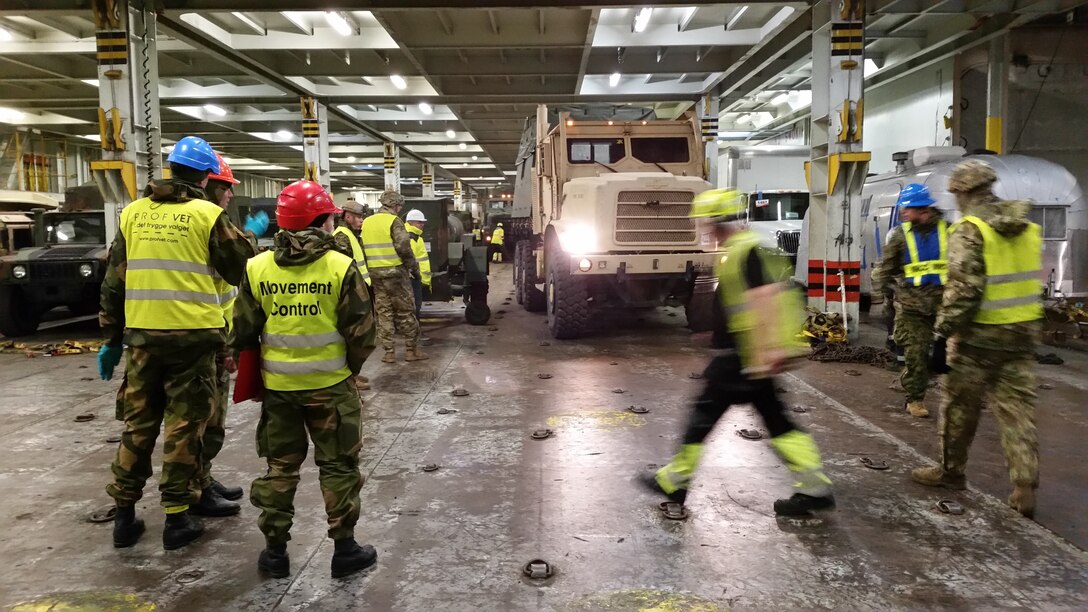 U.S. Marines with II Marine Expeditionary Force, maneuver vehicles to off-load them for NATO exercise Trident Juncture from American Roll-on Roll-off Carrier Resolve in Hammernesodden, Norway, Sept. 23, 2018. Marines and service members from the Norwegian Armed Services unloaded nearly 200 military vehicles and more than 70 containers with military equipment in two days despite cold weather with periods of rain and sleet. (Photo by Kyle Soards)