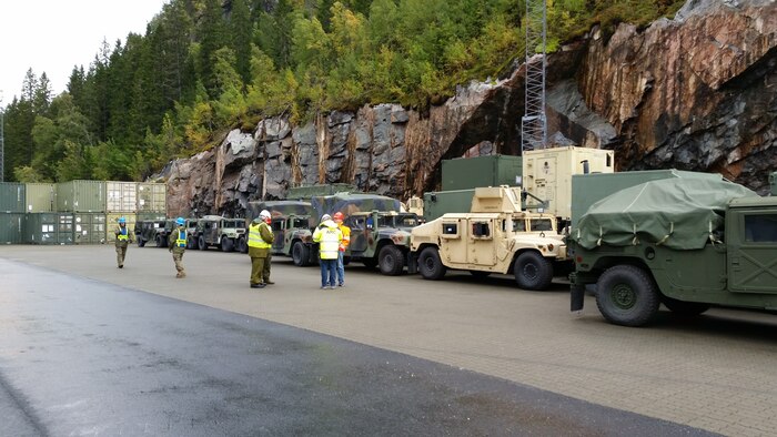 U.S. Marines with II Marine Expeditionary Force, Norwegian service members and federal employees of Norway stage vehicles after off-loading them from the American Roll-on Roll-off Carrier Resolve in preparation for NATO exercise Trident Juncture in Hammernesodden, Norway, Sept. 23, 2018. Marines and service members from the Norwegian Armed Services unloaded nearly 200 military vehicles and more than 70 containers with military equipment in two days despite cold weather with periods of rain and sleet.  (Photo by Kyle Soards)