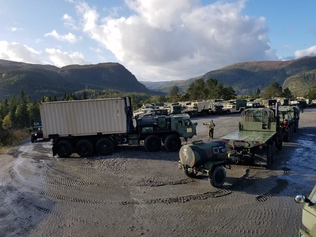 U.S. Marines with II Marine Expeditionary Force, standby to off-load equipment for NATO exercise Trident Juncture from American Roll-on Roll-off Carrier Resolve in Hammernesodden, Norway, Sept. 23, 2018. Marines and service members from the Norwegian Armed Services unloaded nearly 200 military vehicles and more than 70 containers with military equipment in two days despite cold weather with periods of rain and sleet. (Photo by Kyle Soards)