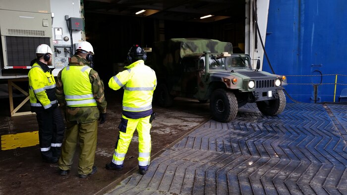 U.S. Marines with II Marine Expeditionary Force, Norwegian service members and federal employees of Norway off-load vehicles in preparation for NATO exercise Trident Juncture from American Roll-on Roll-off Carrier Resolve in Hammernesodden, Norway, Sept. 23, 2018. Marines and service members from the Norwegian Armed Services unloaded nearly 200 military vehicles and more than 70 containers with military equipment  in two days despite cold weather with periods of rain and sleet. (Photo by Kyle Soard)