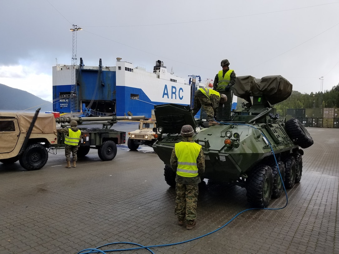 U.S. Marines with II Marine Expeditionary Force, maneuver vehicles while off-loading equipment for NATO exercise Trident Juncture from American Roll-on Roll-off Carrier Resolve in Hammernesodden, Norway, Sept. 24, 2018. Marines and service members from the Norwegian Armed Services unloaded nearly 200 military vehicles and more than 70 containers with military equipment in two days despite cold weather with periods of rain and sleet. (Photo by Kyle Soard)