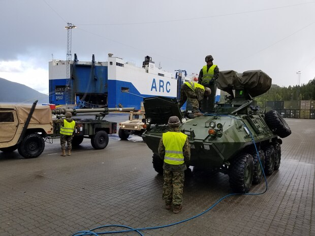 U.S. Marines with II Marine Expeditionary Force, maneuver vehicles while off-loading equipment for NATO exercise Trident Juncture from American Roll-on Roll-off Carrier Resolve in Hammernesodden, Norway, Sept. 24, 2018. Marines and service members from the Norwegian Armed Services unloaded nearly 200 military vehicles and more than 70 containers with military equipment in two days despite cold weather with periods of rain and sleet. (Photo by Kyle Soard)