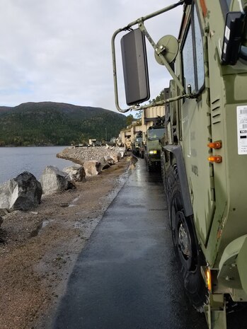 U.S. Marines with II Marine Expeditionary Force, maneuver vehicles after off-loading them from the American Roll-on Roll-off Carrier Resolve for NATO exercise Trident Juncture in Hammernesodden, Norway, Sept. 24, 2018. Marines and service members from the Norwegian Armed Services unloaded nearly 200 military vehicles and more than 70 containers with military equipment in two days despite cold weather with periods of rain and sleet.  (Photo by Kyle Soard)