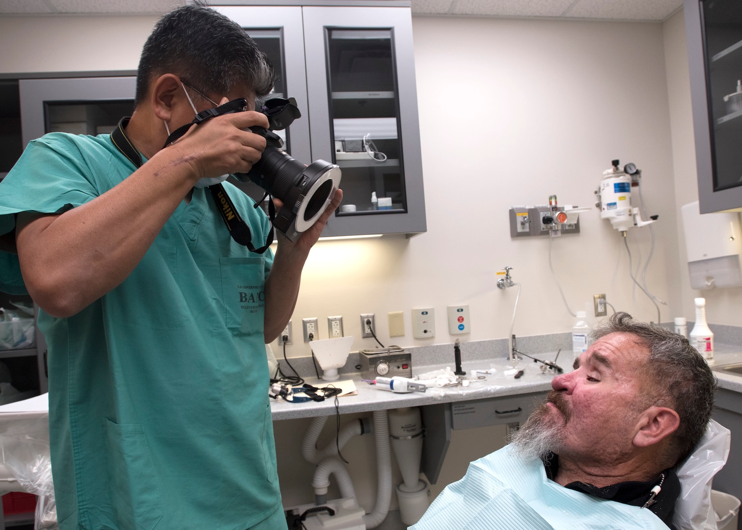 Lt. Col. (Dr.) Young J. Honnlee, 59th Medical Wing maxillofacial prosthodontics fellow, takes a photo of a patient at San Antonio Military Medical Center, Joint Base San Antonio-Fort Sam Houston, Texas. Honnlee documents the healing progress of the patient. (U.S. Air Force photo by Staff Sgt. Kevin Iinuma)