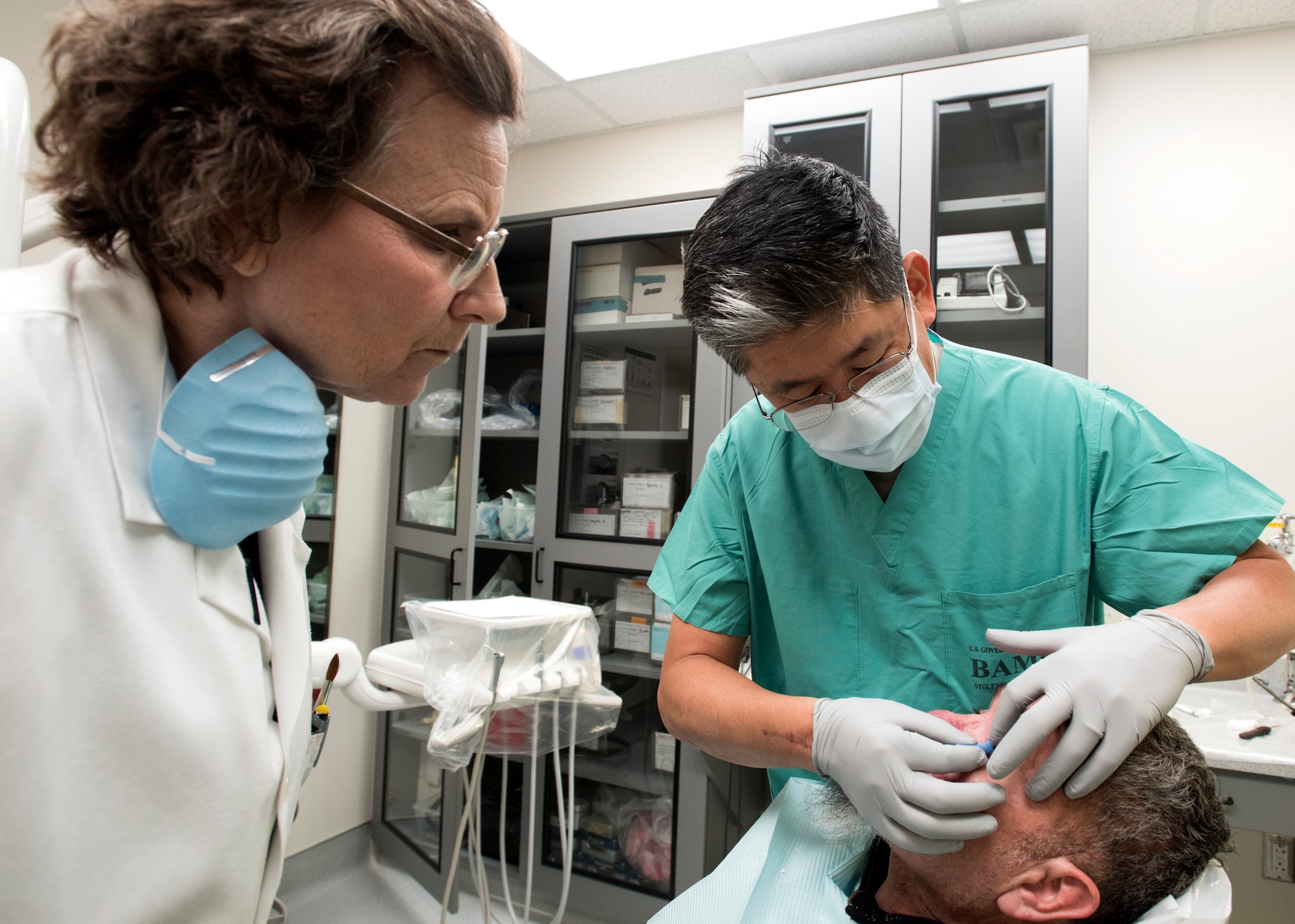 Ms. Nancy Hansen (left), 59th Dental Training Squadron anaplastologist, and Lt. Col (Dr.) Young J. Honnlee, 59th Medical Wing maxillofacial prosthodontics fellow, inspect a patient’s eye socket at San Antonio Military Medical Center, Joint Base San Antonio-Fort Sam Houston, Texas. Hansen and Honnlee work together in creating a prosthetic eye for the patient. (U.S. Air Force photo by Staff Sgt. Kevin Iinuma)