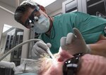 Lt. Col. (Dr.) Young J. Honnlee, 59th Medical Wing maxillofacial prosthodontics fellow, evaluates the inside of a patient’s mouth at San Antonio Military Medical Center, Joint Base San Antonio-Fort Sam Houston, Texas. Honnlee prepares to make impressions of the patient’s teeth. (U.S. Air Force photo by Staff Sgt. Kevin Iinuma)