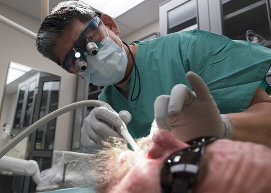 Lt. Col. (Dr.) Young J. Honnlee, 59th Medical Wing maxillofacial prosthodontics fellow, evaluates the inside of a patient’s mouth at San Antonio Military Medical Center, Joint Base San Antonio-Fort Sam Houston, Texas. Honnlee prepares to make impressions of the patient’s teeth. (U.S. Air Force photo by Staff Sgt. Kevin Iinuma)