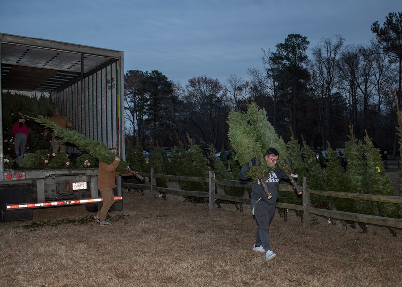 Volunteers unload trees from a trailer during the Christmas SPIRIT Foundation’s Trees for Troops program at Bethel Park, Hampton, Virginia, Dec. 7, 2018.