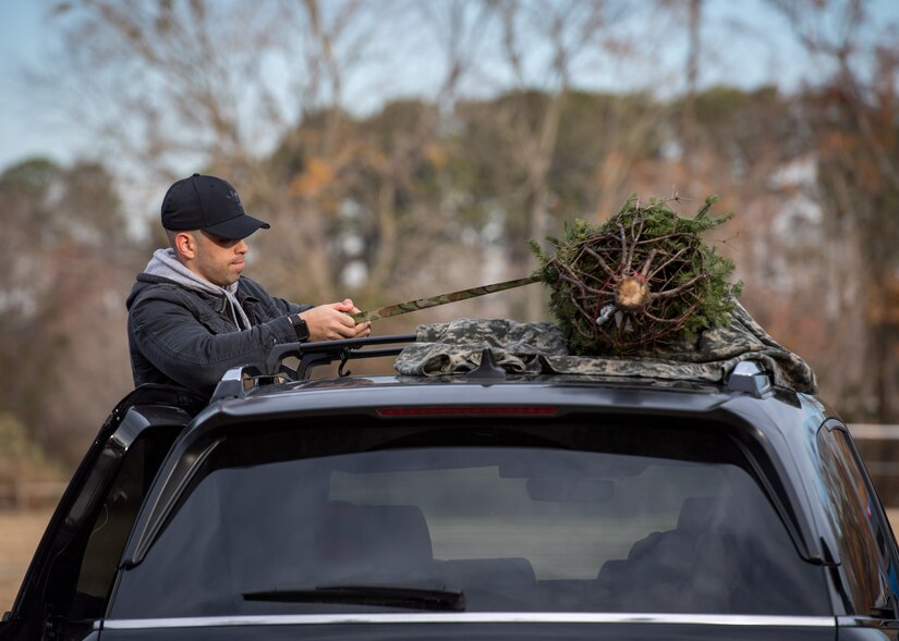U.S. Air Force Airman 1st Bryan Moreno Franco, 633rd Force Support Squadron outbound assignments technician, straps a Christmas tree to the roof of a car while volunteering for the Christmas SPIRIT Foundation’s Trees for Troops program at Bethel Park, Hampton, Virginia, Dec. 7, 2018.