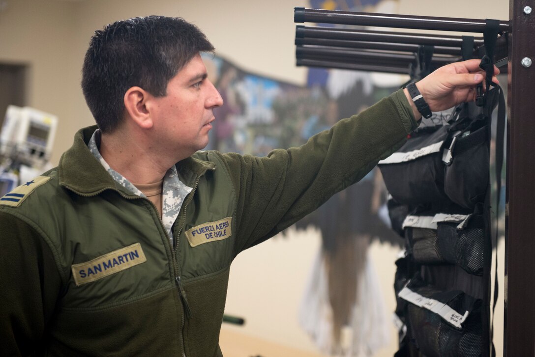 Chilean Air Force 1st Lt. Juan San Martin, medical health officer, looks at a Critical Care Air Transport Team’s medical supply kit on Dec. 7, at Camp Bramble on Joint Base San Antonio-Lackland, Texas. Each CCATT carries roughly 560 pounds of gear, enough to continue the level of acute care for three critically ill patients up to 24-hours. (U.S. Air Force photo by Kiley Dougherty)