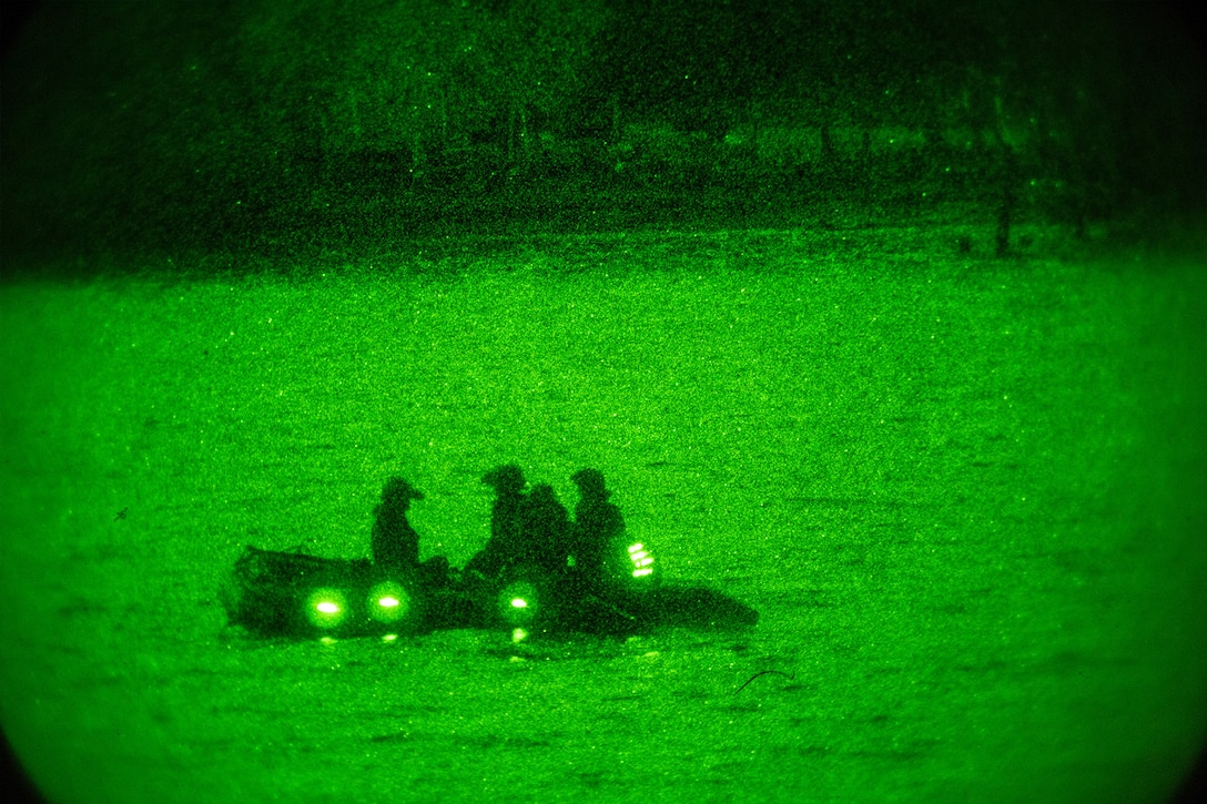 Marines conduct reconnaissance training at night in a rubber craft.