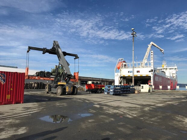 U.S. Marines, U.S. Sailors, Norwegian Soldiers, and civilians work together to offload equipment that will be used during Trident Juncture 18 at Trondheim Port, Norway, on Oct. 11, 2018. Trident Juncture 18 enhances the U.S. and NATO Allies' abilities to work together collectively to conduct military operations under challenging conditions. (U.S. Marine Corps photo by Maj. Jordan Cochran)