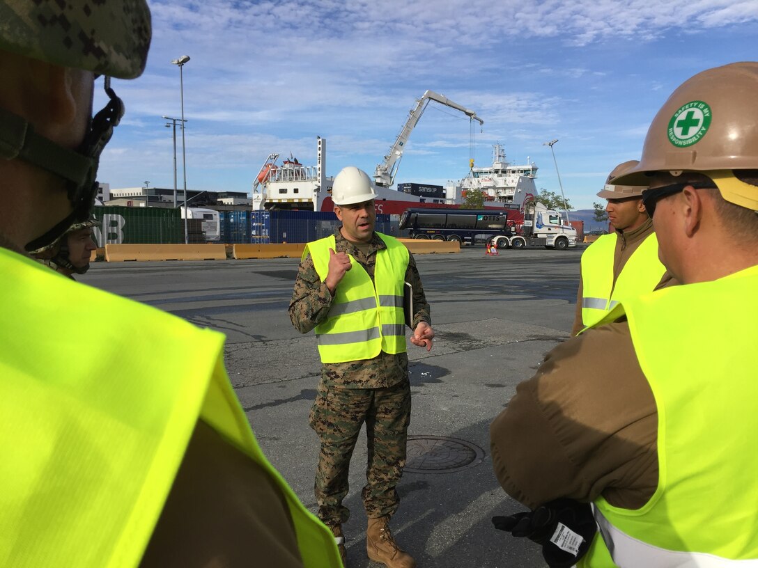 U.S. Marine Col. John Sullivan, 2d Marine Expeditionary Brigade chief of staff, speaks to U.S. Marines and Sailors, Norwegian Soldiers, and civilians as they work together to offload equipment that will be used during Trident Juncture 18 at Trondheim Port, Norway, on Oct. 11, 2018. Trident Juncture 18 enhances the U.S. and NATO Allies' abilities to work together collectively to conduct military operations under challenging conditions. (U.S. Marine Corps photo by Maj. Jordan Cochran)