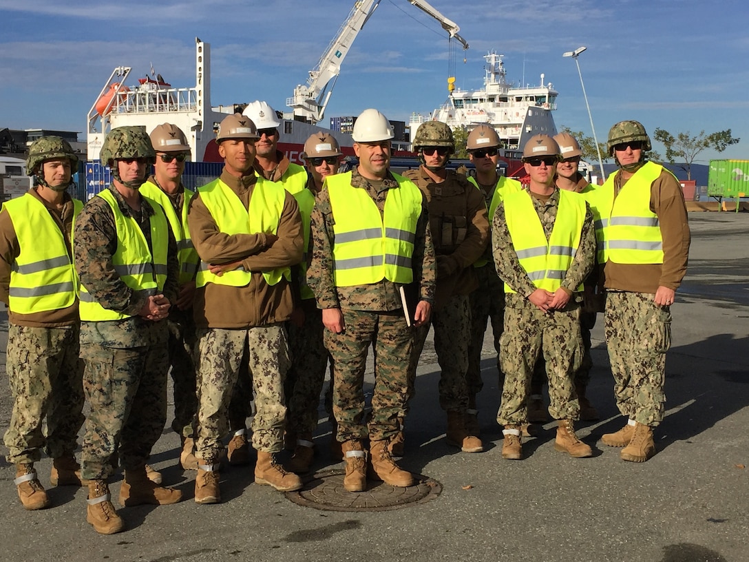 U.S. Marine Col. John Sullivan, 2d Marine Expeditionary Brigade chief of staff, stands with U.S. Marines and Sailors who worked together to offload equipment that will be used during Trident Juncture 18 at Trondheim Port, Norway, on Oct. 11, 2018. Trident Juncture 18 enhances the U.S. and NATO Allies' abilities to work together collectively to conduct military operations under challenging conditions. (U.S. Marine Corps photo by Maj. Jordan Cochran)