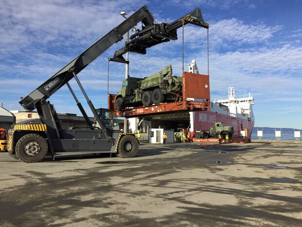 U.S. Marines, Norwegian Soldiers, and civilians work together to offload equipment that will be used during Trident Juncture 18 at Trondheim Port, Norway, on Oct. 11, 2018. Trident Juncture 18 enhances the U.S. and NATO Allies' abilities to work together collectively to conduct military operations under challenging conditions. (U.S. Marine Corps photo by Maj. Jordan Cochran)