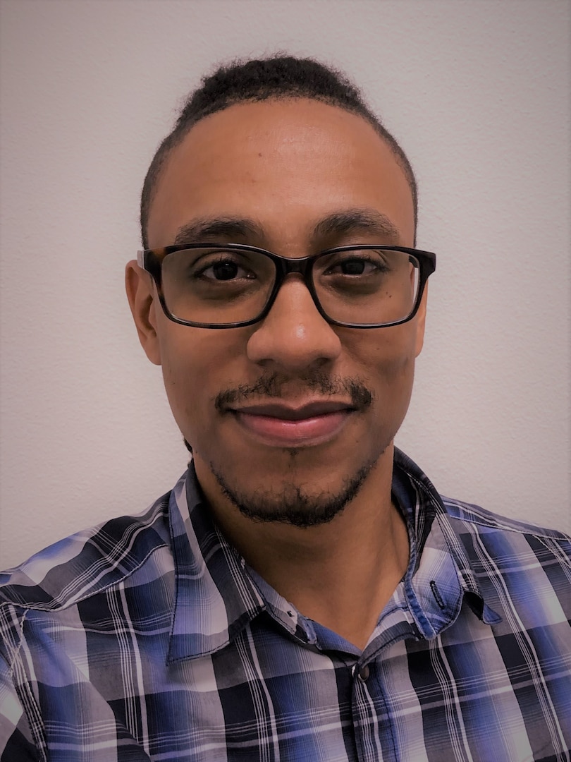 Portrait photo of a male wearing a black and blue shirt