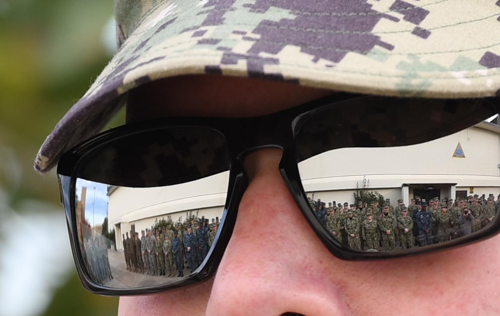 Keesler personnel attend the Center for Naval Aviation Technical Training Unit Keesler Pearl Harbor 77th Anniversary Remembrance Ceremony as seen through the sunglasses reflection of U.S. Navy Aviation Electronics Technician 1st Class Nathaniel Eakins, CNATTU Keesler instructor, at Keesler Air Force Base, Mississippi, Dec. 7, 2018. More than 100 Keesler personnel attended the event to honor those lost in the Dec. 7, 1941, Pearl Harbor attacks. (U.S. Air Force photo by Kemberly Groue)