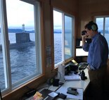 Bill Fagan, a trial director at Naval Surface Warfare Center, Carderock Division, measures the distance to the Virginia-class fast-attack submarine USS Texas (SSN 775) as they prepare to submerge the boat for an exercise on Oct. 26, 2018, in Carderock's Southeast Alaska Acoustic Measurement Facility (SEAFAC) static site off the coast of Ketchikan, Alaska. (U.S. Navy photo by Kelley Stirling/Released)