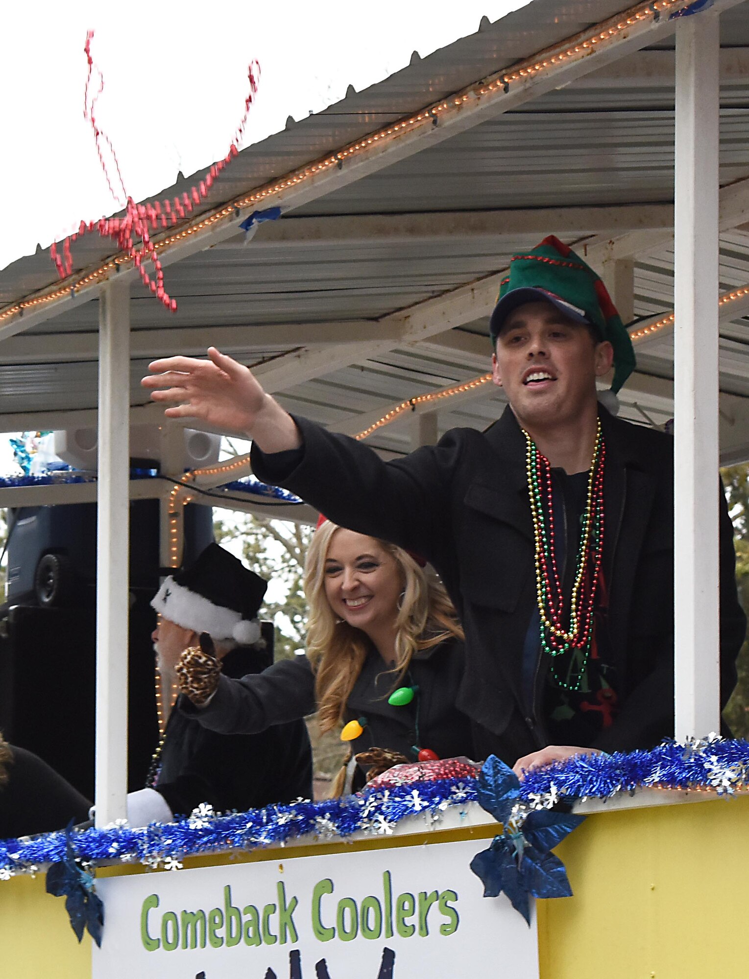 Shea Dobson, Ocean Springs Mayor, tosses beads into the crowd during the Ocean Springs Christmas Parade in Ocean Springs, Mississippi, Dec. 9, 2018. The Keesler Air Force Base Honor Guard and 81st Training Group Airmen participated in the event. (U.S. Air Force photo by Kemberly Groue)