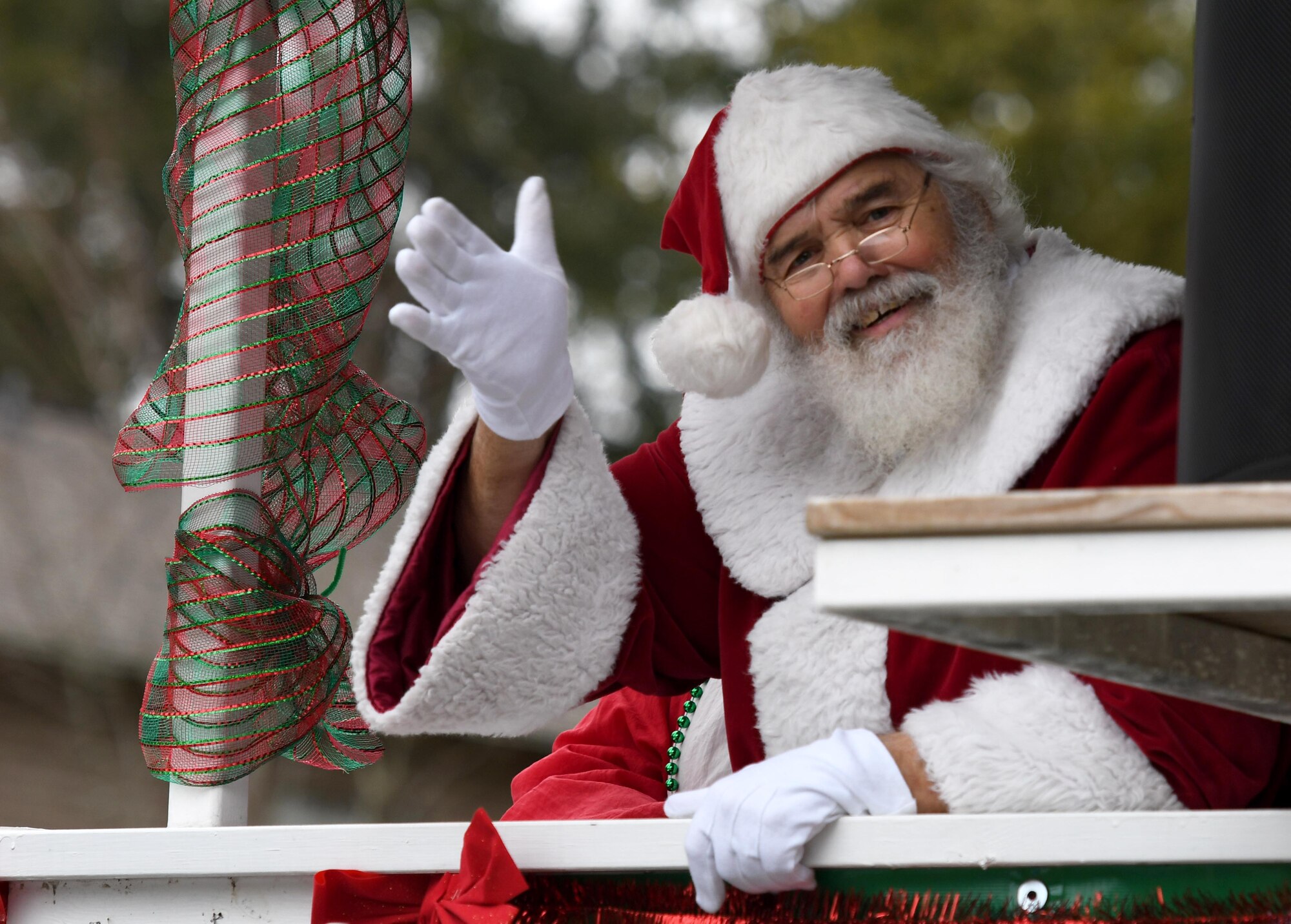 Santa Claus waves to attendees during the Ocean Springs Christmas Parade in Ocean Springs, Mississippi, Dec. 9, 2018. The Keesler Air Force Base Honor Guard and 81st Training Group Airmen participated in the event. (U.S. Air Force photo by Kemberly Groue)