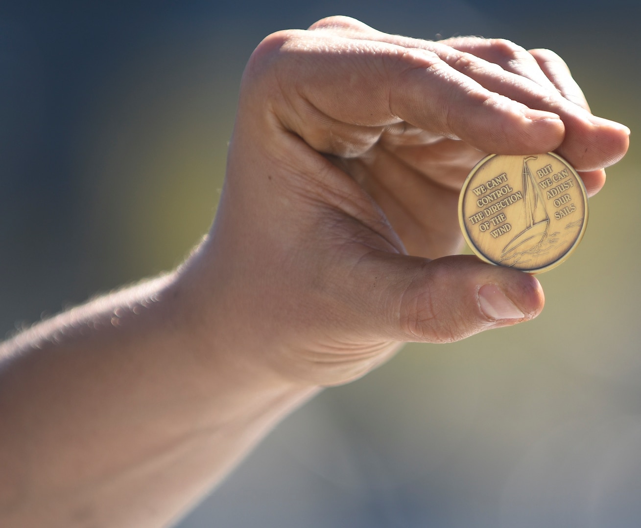 A Soldier holds his Substance Use Disorder Clinical Care commencement coin.