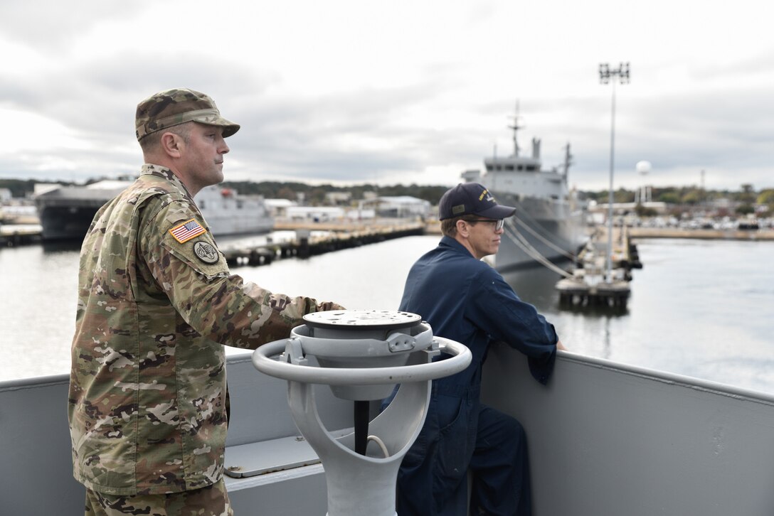 U.S. Army Chief Warrant Officer 2 Joel Grover, 335th Transportation Detachment, 10th Trans. Battalion, 7th Trans. Brigade (Expeditionary) second mate, and Chief Warrant Officer Matthey Godfrey, 335th Transportation Detachment, 10th Trans. Battalion, 7th Trans. Brigade (Expeditionary) vessel master, give navigation commands to the U.S. Army Soldier who is at the helm of the vessel at the port of Joint Expeditionary Base Little Creek-Fort Story, Virginia, Nov. 5, 2018. The vessel master is in charge of the navigation of the vessel, however a leading seaman is usually at the helm doing the steering. (U.S. Army photo by Spc. Travis Teate)