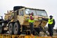 Members of the 841st Transportation Battalion ride with military vehicles on a rail flatcar Dec. 10, 2018, at Joint Base Charleston, S.C.