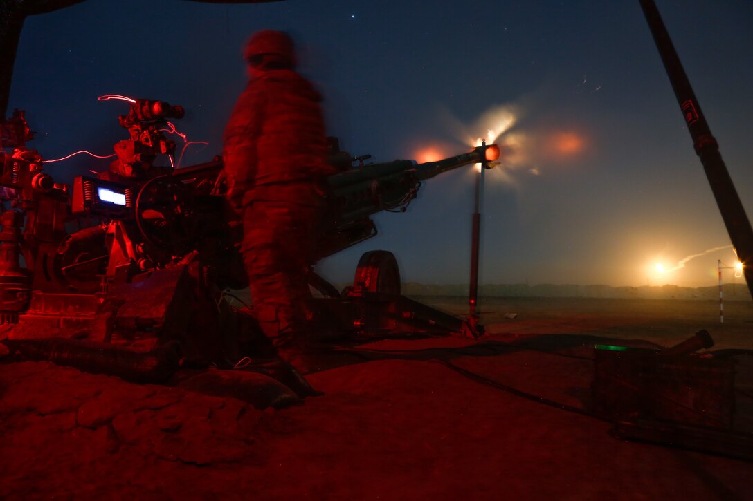 Soldiers shoot howitzer