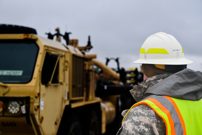 Chief Warrant Officer Bryan Smith, 841st Transportation Battalion mobility officer, watches for safety as military vehicles are prepared to be unloaded Dec. 10, 2018, at Joint Base Charleston, S.C.
