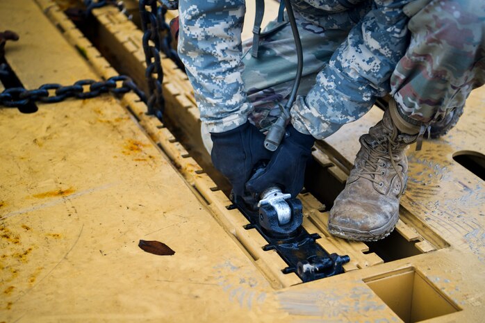 A soldier from the 1st Infantry Division takes the chains off a military vehicle Dec. 10, 2018 at Joint Base Charleston, S.C.