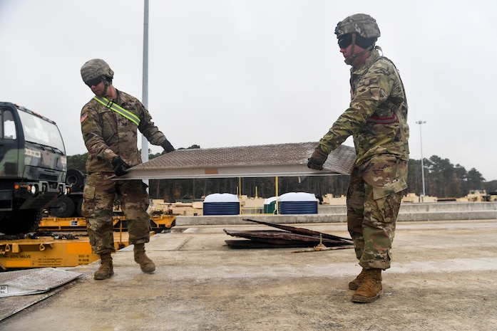Soldiers from the 1st Infantry Division move a loading ramp Dec. 10, 2018, at Joint Base Charleston, S.C.