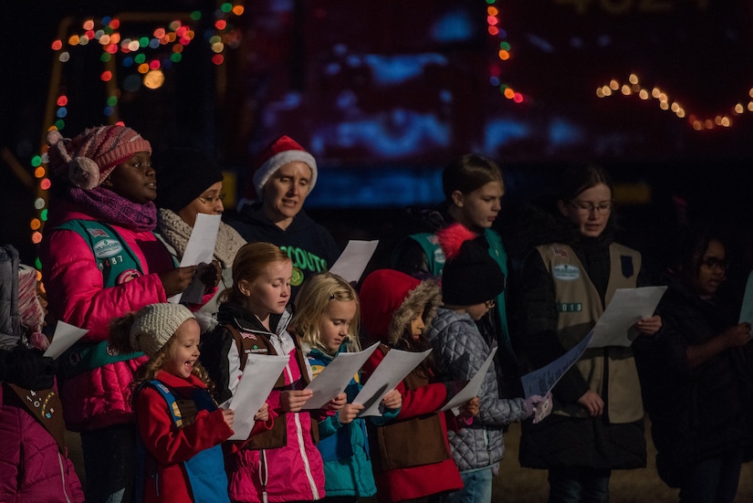 The Girl Scouts of the Colonial Coast sing carols during the Holiday Tree Lighting ceremony at Fort Eustis, Virginia, Dec. 7, 2018.