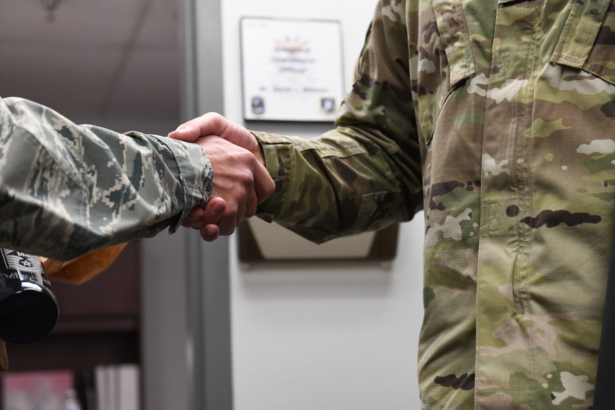 Senior Master Sgt. Jesse Frank, the 28th Security Forces Squadron operations superintendent, shakes hands with Chief Master Sgt. Justin Walker, the 28th Bomb Wing interim command chief at Ellsworth Air Force Base, S.D., Dec. 4, 2018. Frank was informed that he’d been selected for the highest enlisted rank: chief master sergeant. (U.S. Air Force photo by Airman 1st Class Thomas Karol)