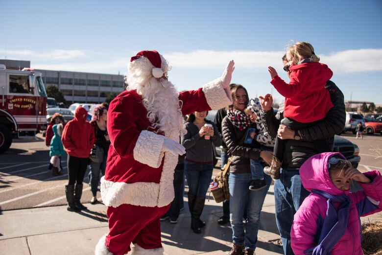 Santa Claus high-five’s a child during the Annual Children’s Holiday Festival Winter Extravaganza at the fitness center at Schriever Air Force Base, Colorado, Dec. 1, 2018. More than 500 children and their families attended the event designed to bring some holiday cheer to Schriever members. (U.S. Air Force photo by 2nd Lt. Idalí Beltré Acevedo)