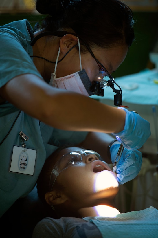 Lt. Ya Li, from Littleton, Colo., performs a dental operation on a patient at one of two medical sites.