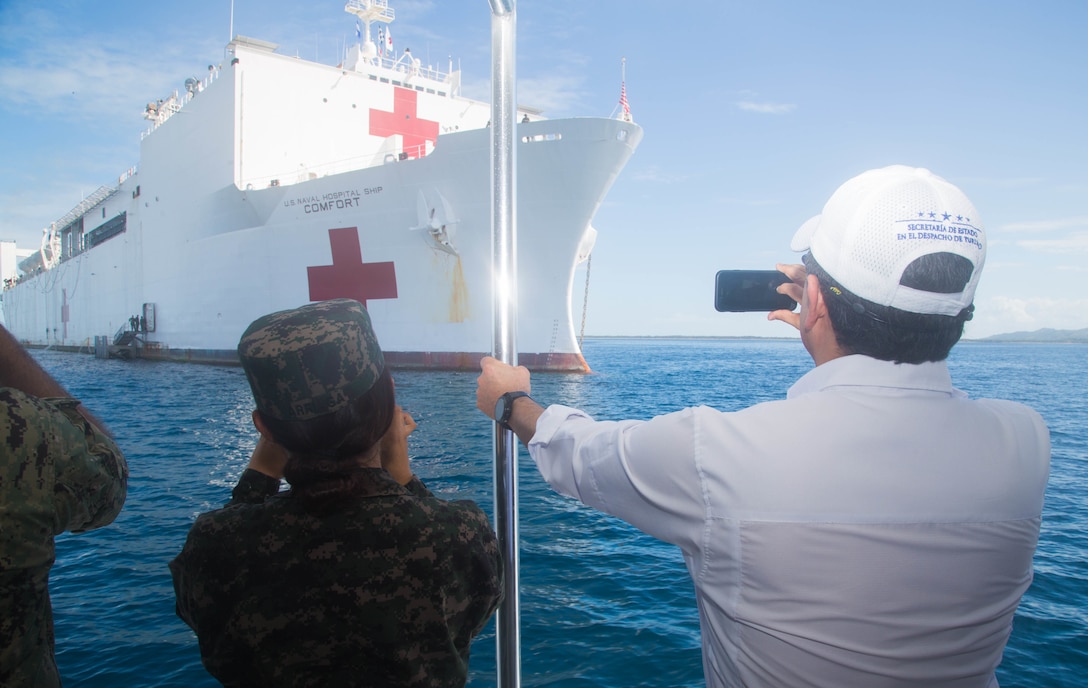 President Juan Orlando Hernandez of Honduras takes a picture as he is transported to the hospital ship USNS Comfort (T-AH 20) for a tour and luncheon.