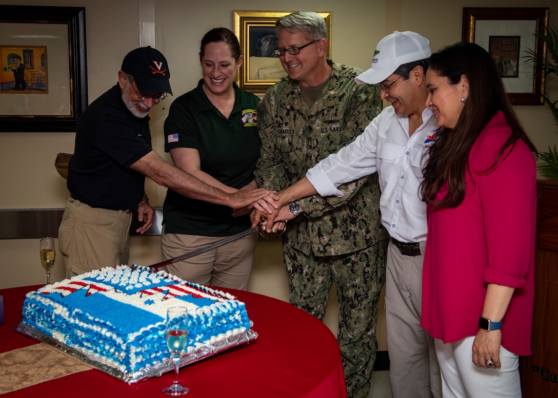 Capt. William Shafley, commander, Task Force 49 (center), President Juan Orlando Hernandez of Honduras (center-right), First Lady Ana Rosalinda Garcia Carias de Hernandez (right), Heide Fulton, Charge d’Affaires at the U.S. embassy in Honduras (center-left) and Sergio de la Pena, U.S. deputy assistant secretary of defense for western hemisphere affairs, cut a cake during a luncheon hosted aboard the hospital ship USNS Comfort (T-AH 20).