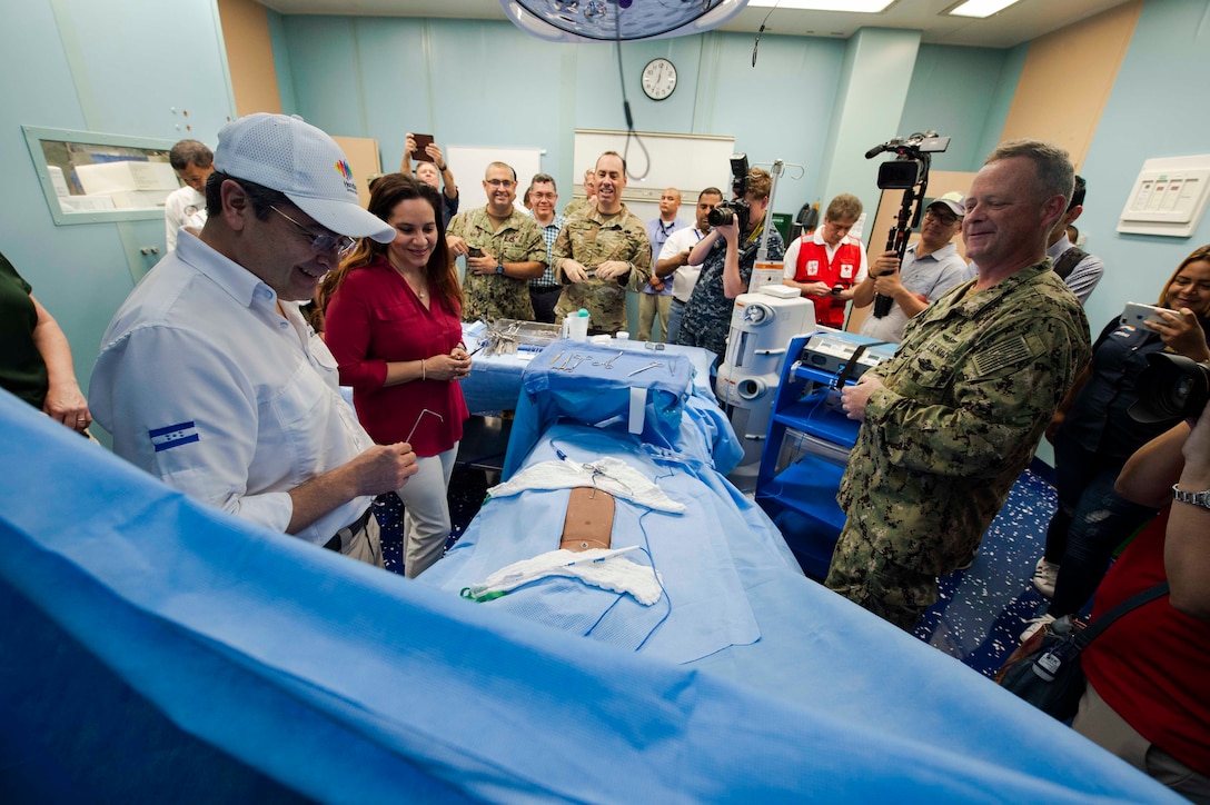 U.S. Navy Capt. Kevin Buckley (right), commanding officer, Medical Treatment Facility, aboard the hospital ship USNS Comfort (T-AH 20), gives a tour of the ship to President Juan Orlando Hernandez of Honduras and First Lady Ana Rosalinda Garcia Carias de Hernandez.