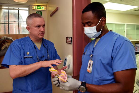 U.S. Air Force Maj. Jeremy Matis, 48th Dental Squadron general dentist, and Tech. Sgt. Andre Andrews, 48th DS dental technician, discuss a patient’s dental impressions at the RAF Mildenhall Dental Clinic, RAF Mildenhall, England, Dec. 3, 2018. The 48th DS, which is permanently based at RAF Lakenheath, consists of 108 personnel – dental officers, enlisted technicians, administrators, medical equipment technicians and other essential personnel.  (U.S. Air Force photo by Airman 1st Class Brandon Esau)