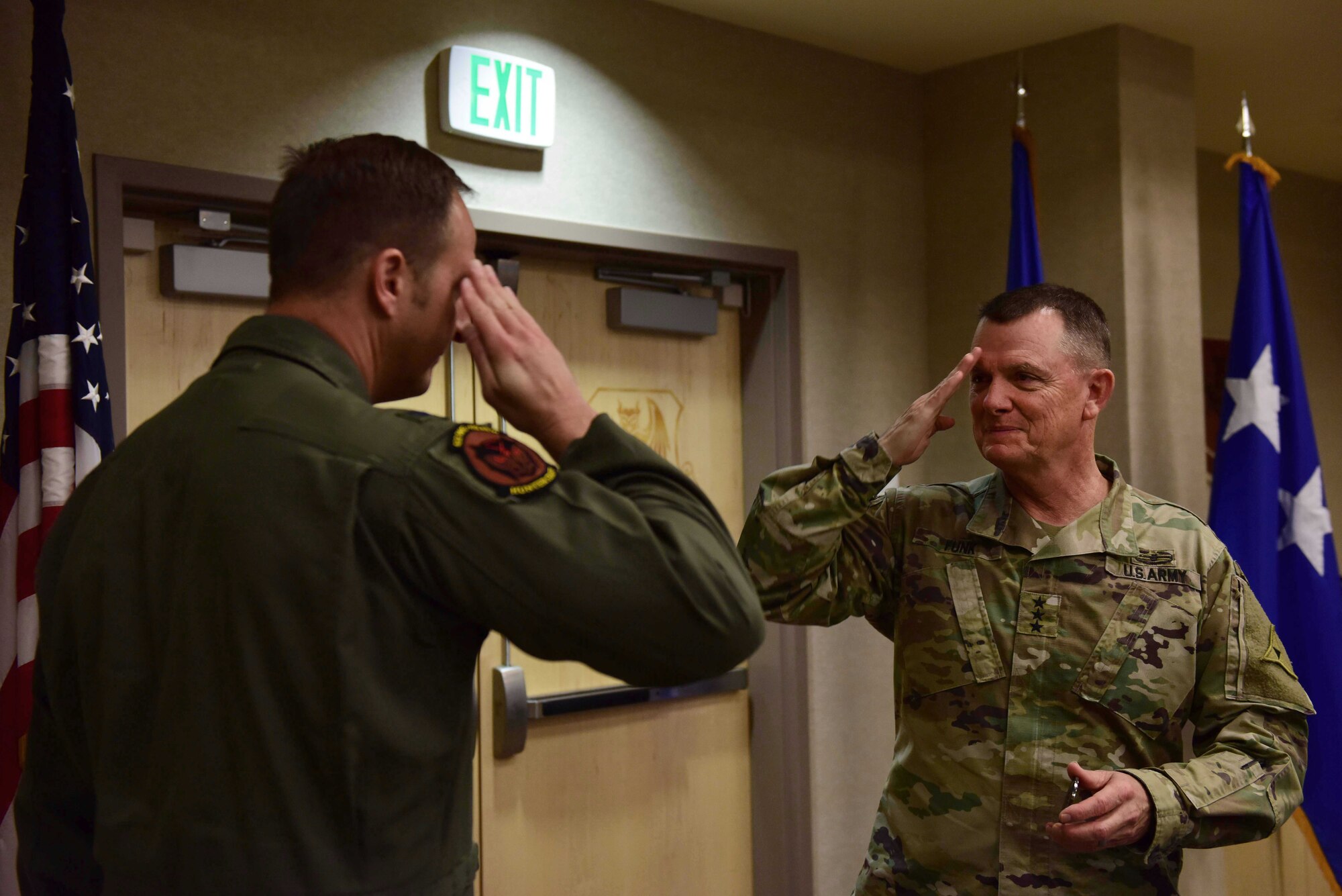 U.S. Air Force Col. Julian Cheater, 432nd Wing/432nd Air Expeditionary Wing commander (left) gifts a 432nd WG coin to U.S. Army Lt. Gen. Paul Funk, III Armored Corps and Fort Hood, Texas, commanding general (right) at Creech Air Force Base, Nevada, Dec. 10, 2018. While visiting Creech, Funk not only gained a better understanding of how 432nd WG Airmen support the Remotely Piloted Aircraft mission in operations such as Enduring Freedom and OIR but also shared some of his combat experiences while in command of OIR. (U.S. Air Force Photo by Airman 1st Class Haley Stevens)