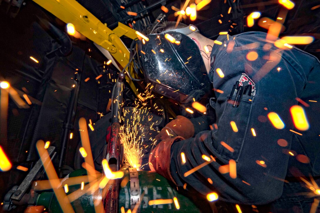 A sailor cuts open an oxygen bottle sending sparks flying everywhere.