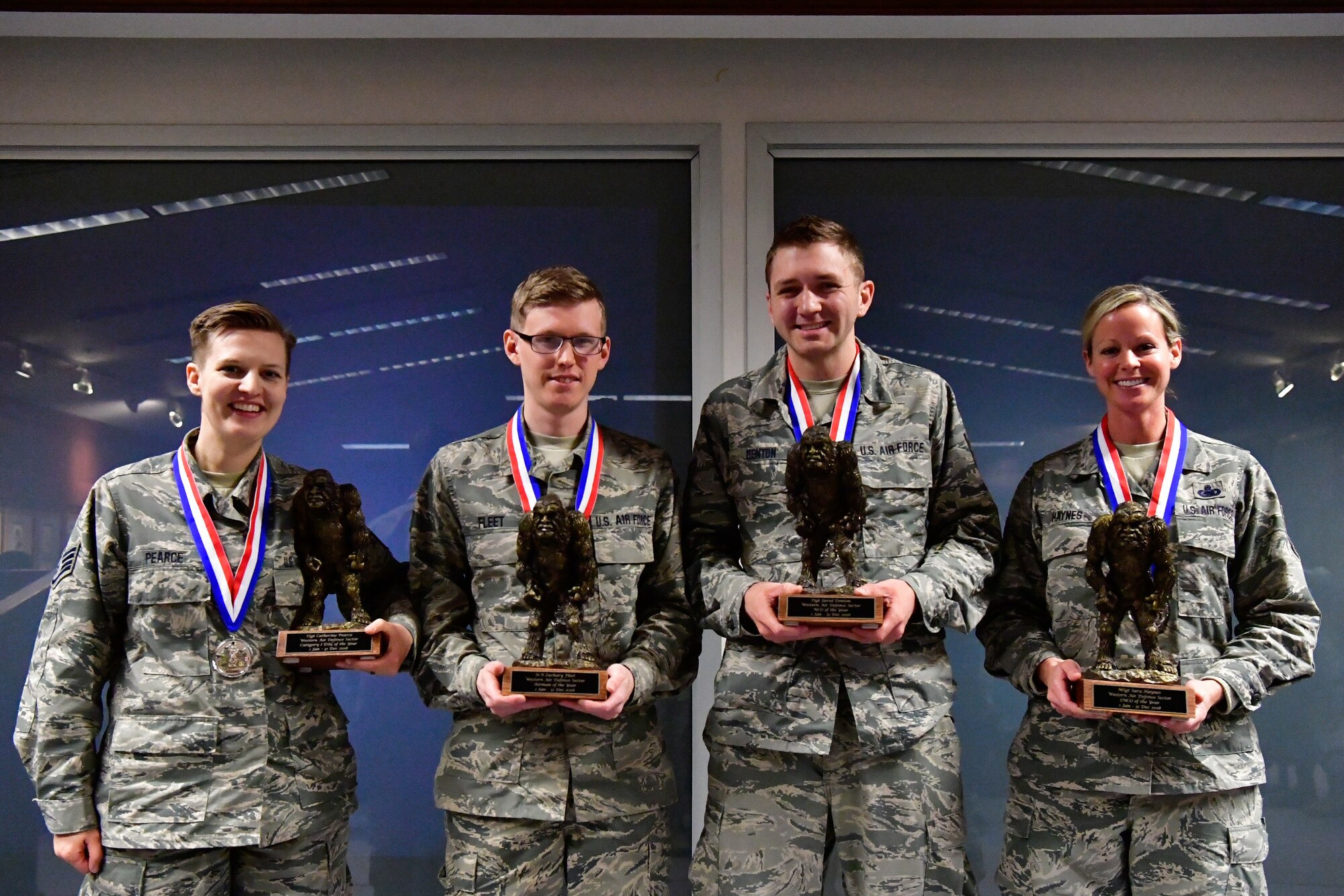 The Western Air Defense Sector annual award winners pose with their Bigfoot trophy Dec. 1, 2018 on Joint Base Lewis-McChord, Washington. Pictured from left to right are Category I Drill Status Guardsmen of the Year Staff Sgt. Catherine Pearce, 225th Support Squadron emergency management specialist; Airman of the Year Senior Airman Zachary Fleet, 225th Air Defense Squadron interface control technician; NCO of the Year Staff Sgt. Jared Denton, 225th ADS NCOIC of surveillance training; and SNCO of the Year Master Sgt. Sara Haynes, 225th SS NCOIC of logistics.  Not pictured are: DSG Company Grade Officer Capt. Colette Muller, 225th Air Defense Group public affairs officer; CGO of the Year Capt. Marvin Yamada, 225th ADS weapons flight commander; Category I Civilian of the Year Barry Arzberger, 225th SS HVAC technician; and Category II Civilian of the Year Bruce Robie; 225th SS National Airspace System Defense program manager.  (U.S. Air National Guard photo by Maj. Kimberly D. Burke)