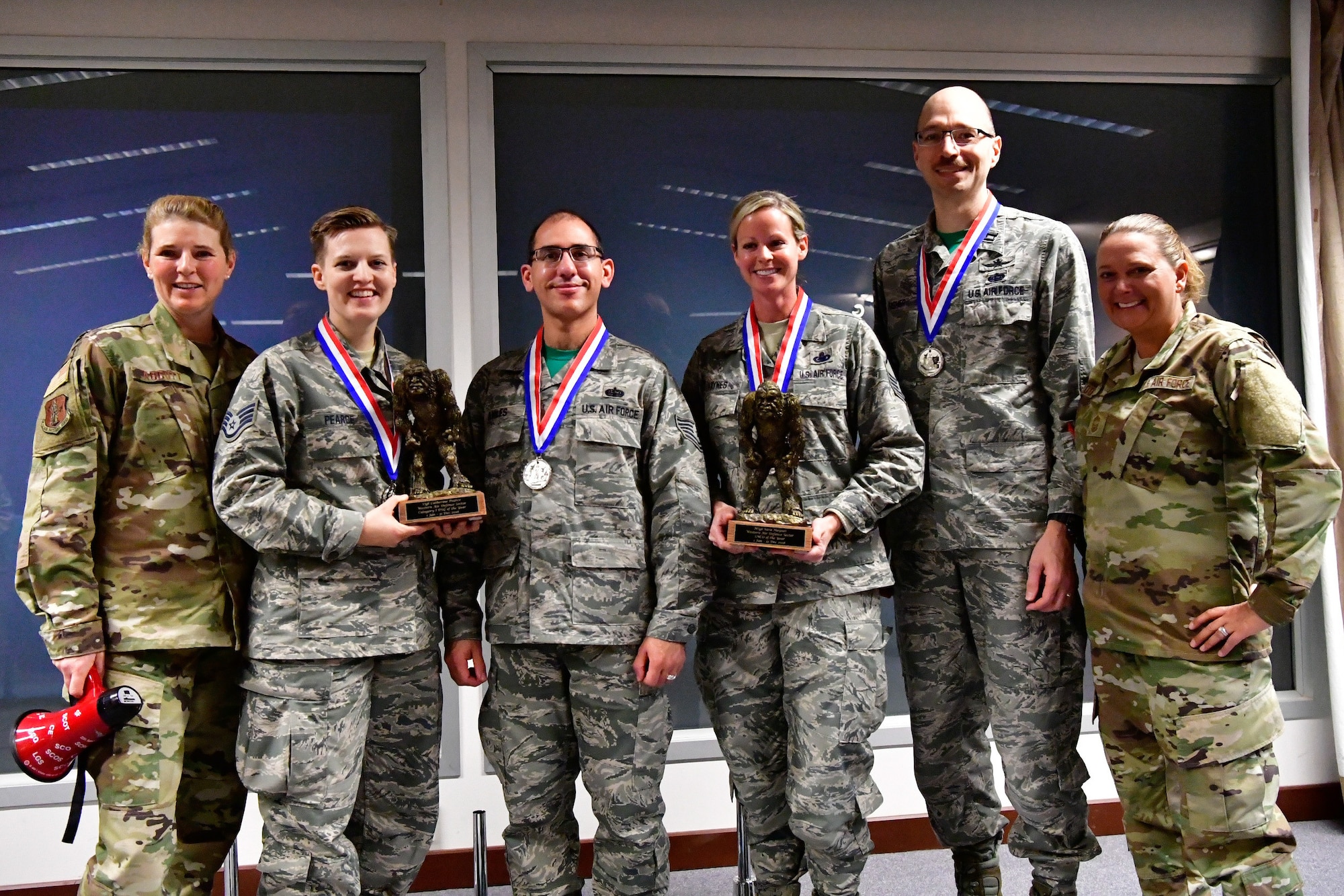 The 225th Support Squdron annual award winners pose with their Bigfoot trophies and medals Dec. 1, 2018 on Joint Base Lewis-McChord, Washington. Pictured from left to right are:  Col. Paige Abbott (left), 225th SS commander;  Category I Drill Status Guardsmen of the Year Staff Sgt. Catherine Pearce, emergency management specialist; NCO of the Year Tech. Sgt. Edwin Aviles, 225th Support Squadron cyber infrastructure technician; SNCO of the Year Master Sgt. Sara Haynes, NCOIC of logistics; CGO of the Year Capt. Paul Fisher, chief of mission system and Chief Master Sgt. Laurie Doyle, 225th SS chief enlisted manager.  Not pictured are: Category I Civilian of the Year Barry Arzberger, HVAC technician; Category II Civilian of the Year Bruce Robie,  National Airspace System Defense program manager (U.S. Air National Guard photo by Maj. Kimberly D. Burke)