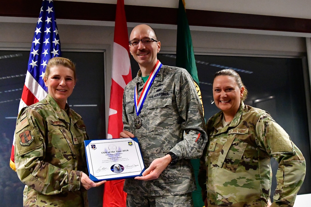 Capt. Paul Fisher, 225th Support Squadron chief of mission system is named the 225th SS Company Grade Officer of the Year Dec. 1, 2018 on Joint Base Lewis-McChord.  Fisher poses with Col. Paige Abbott (left), 225th SS commander and Chief Master Sgt. Laurie Doyle, 225th SS chief enlisted manager. (U.S. Air National Guard photo by Maj. Kimberly D. Burke)